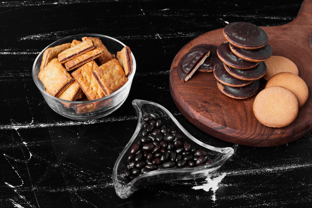Chocolate sponge cookies on a wooden board with crackers